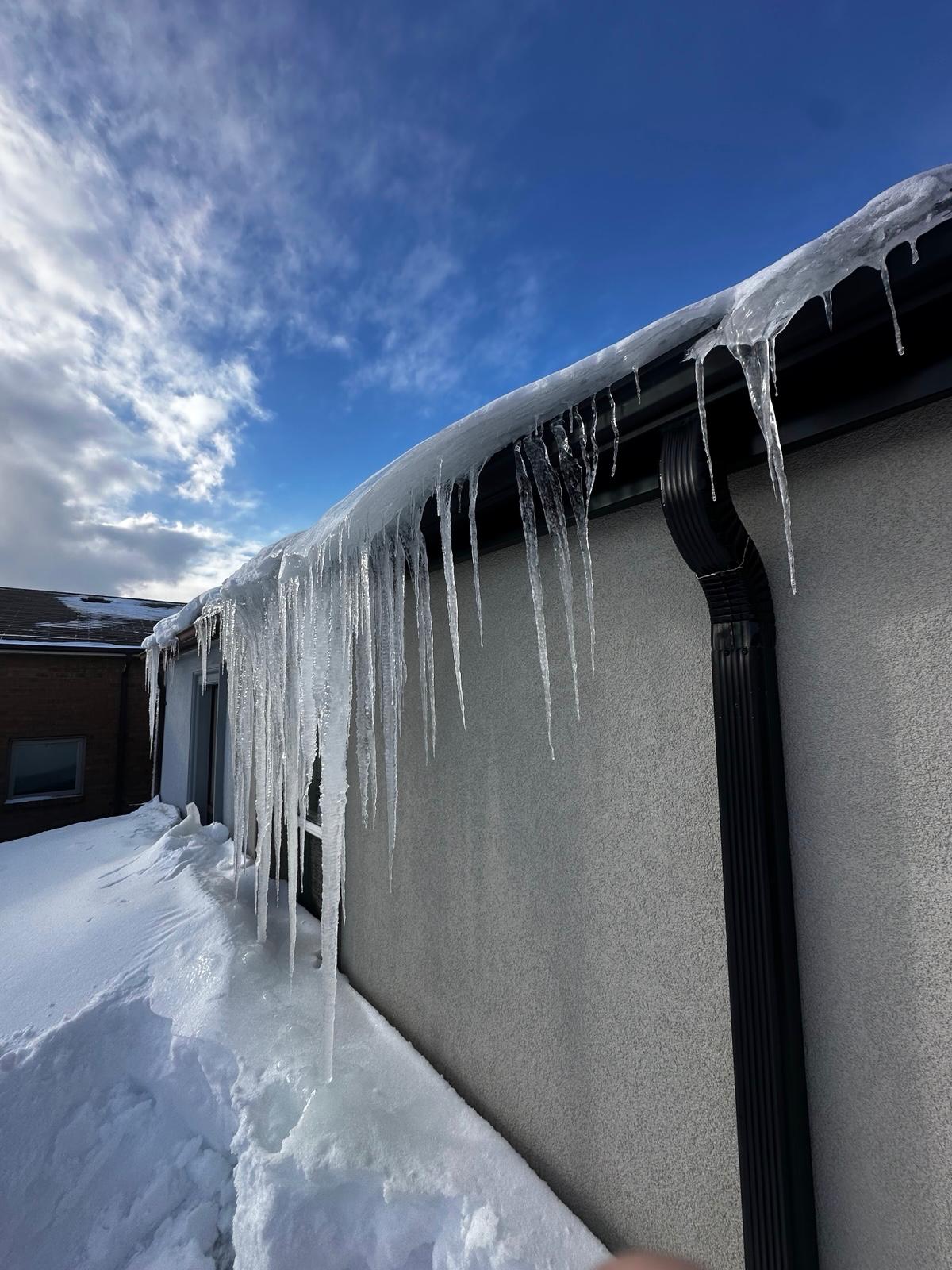 Roof snow and ice buildup requiring removal by Beaver Roofing
